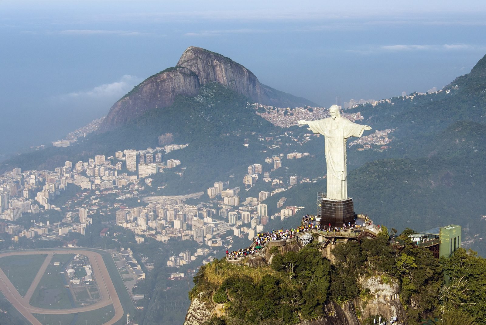 Aerial view of Christ the Redeemer on top of Corcovado, with the city and the mountains of Rio's South Zone in the background