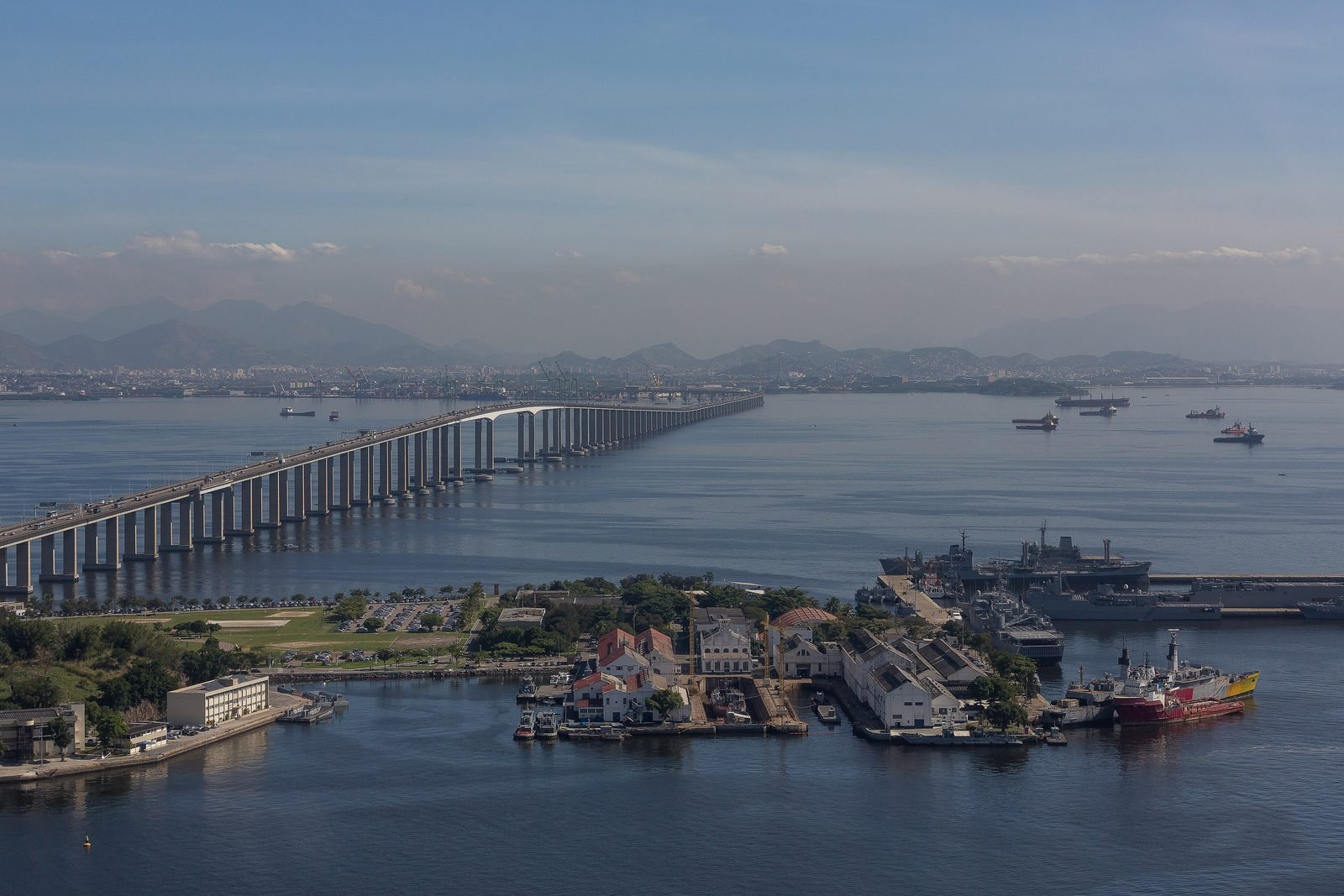 Aerial view of the Rio–Niterói Bridge crossing Guanabara Bay, with Mocanguê Island and ships in the foreground