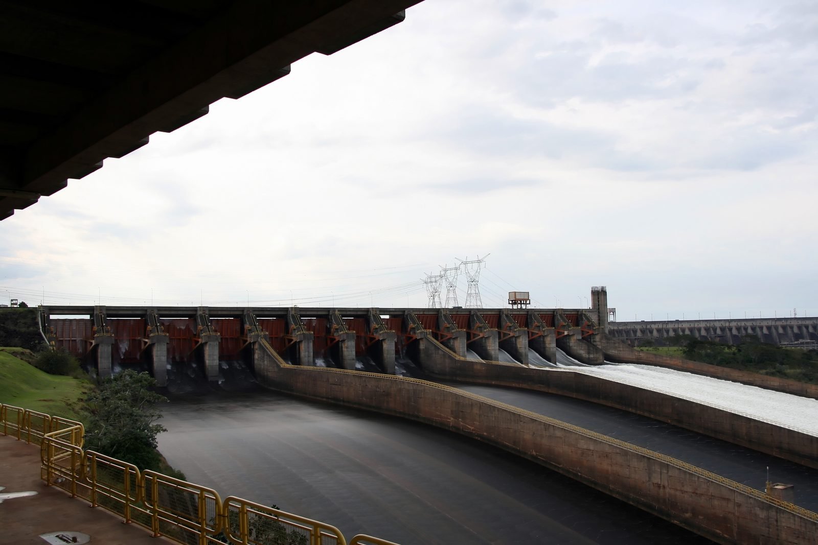 The Itaipu spillway with some of its gates open and water rushing down the concrete chutes