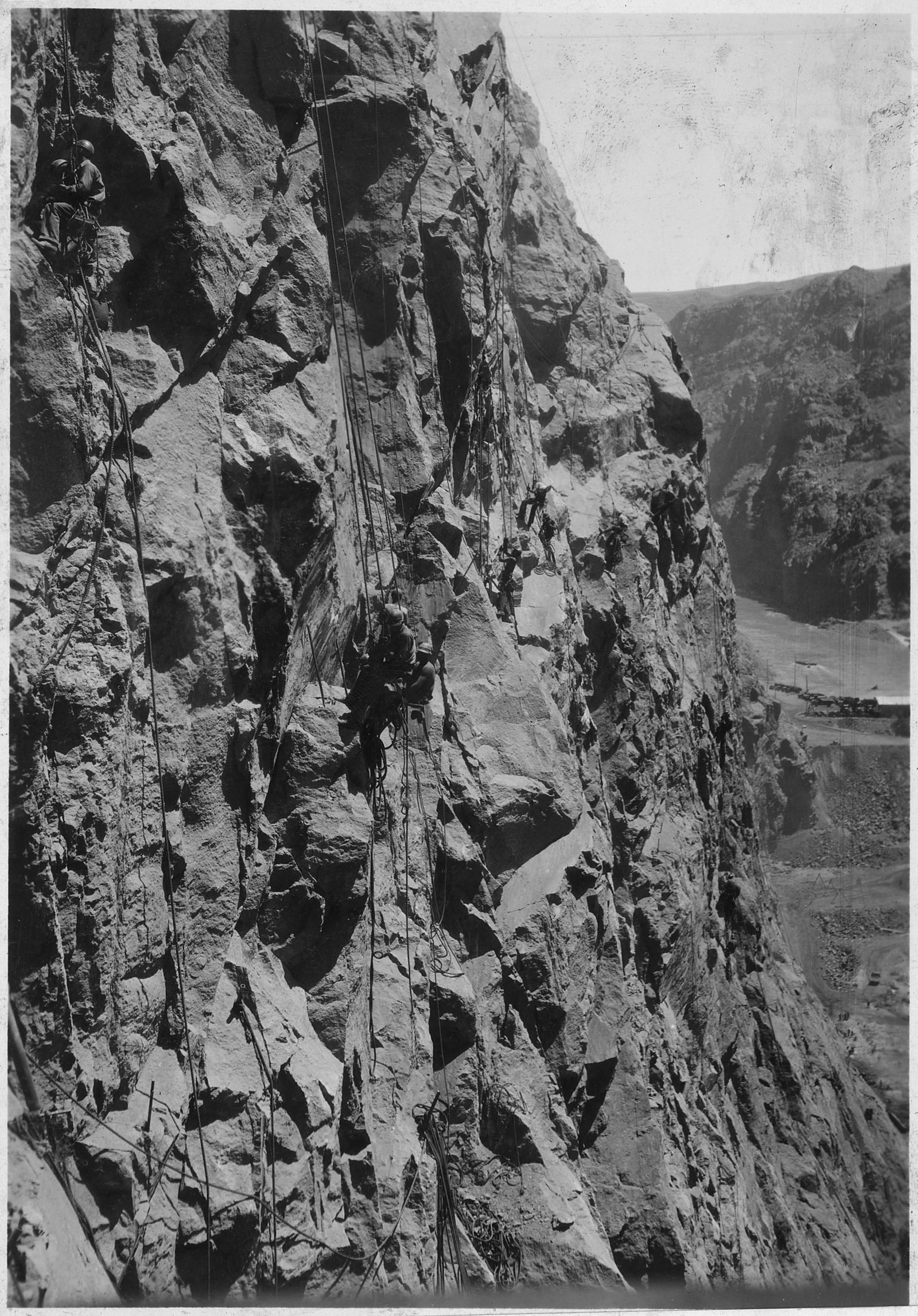 Hombres colgados de cuerdas en una pared vertical de roca del cañón